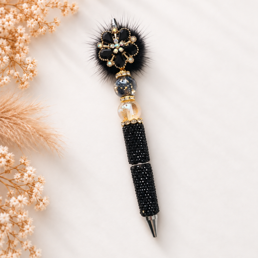 Luxe kralenpen Lumière in zwarte tinten met fonkelende bloem, gouden details en sierlijke kralen