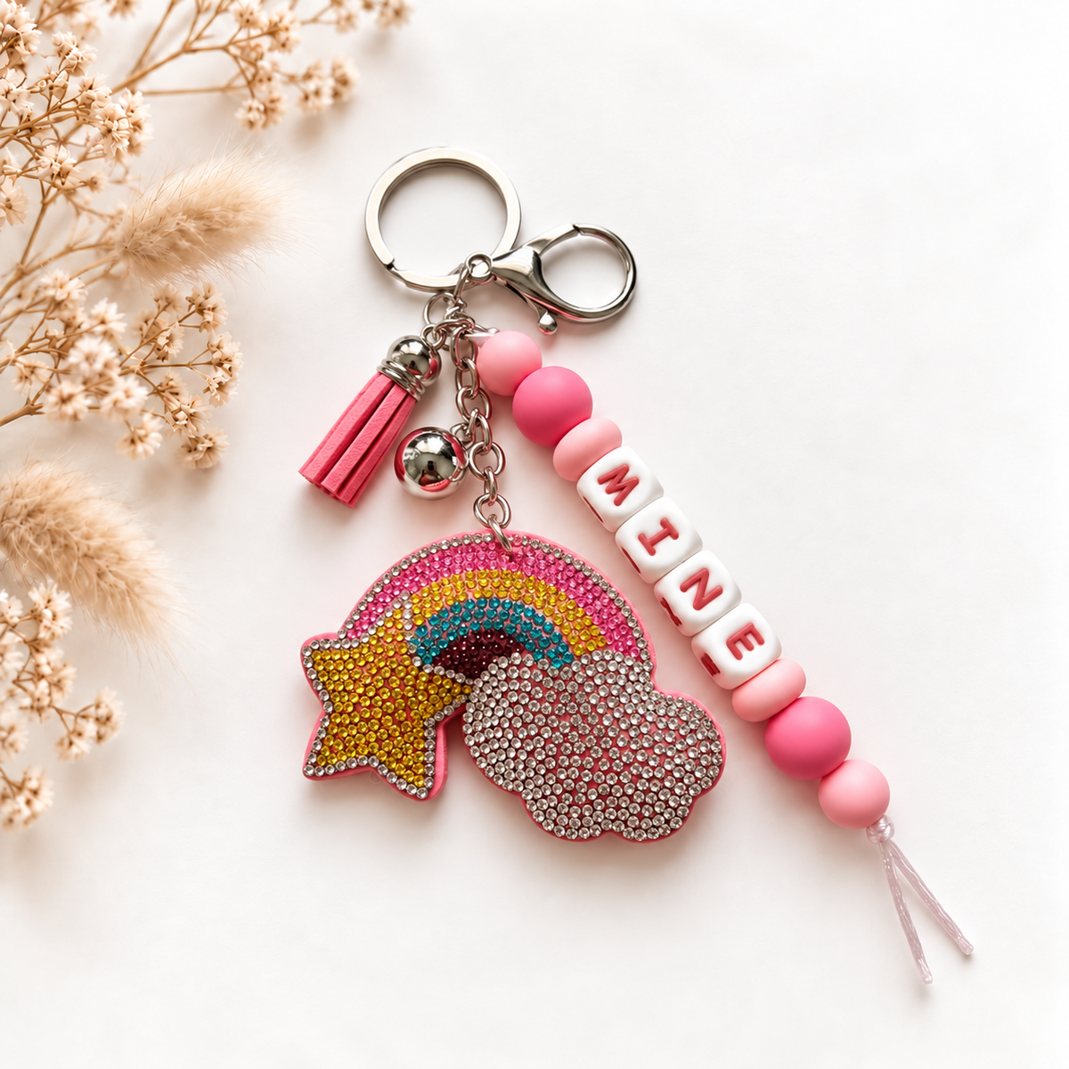 Sleutelhanger en tassenhanger met naam MINE, roze kralen, glinsterende regenboog en roze kwastje