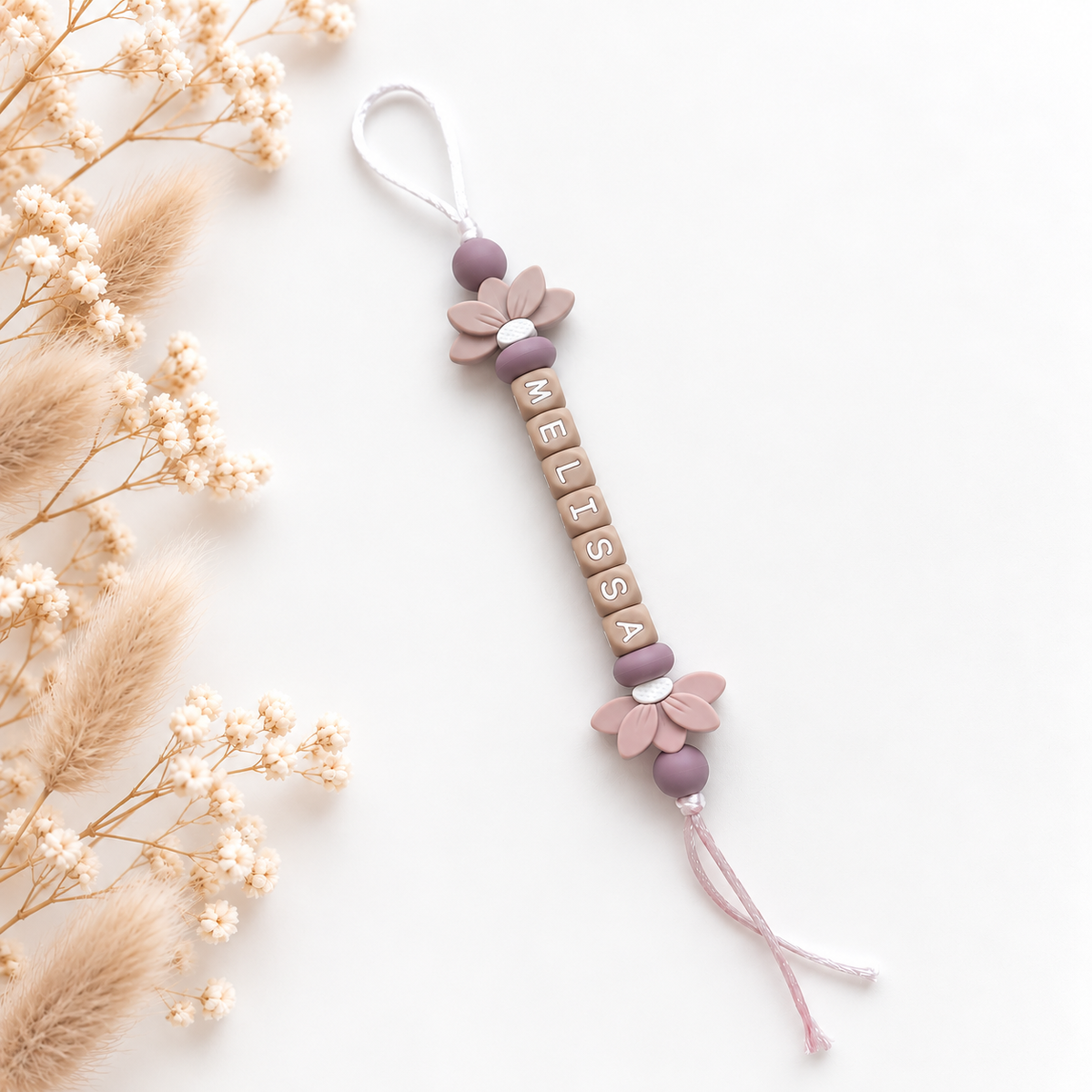 Handgemaakte tassenhanger met naam Melissa in mauve, taupe en beige met twee bloemdetails