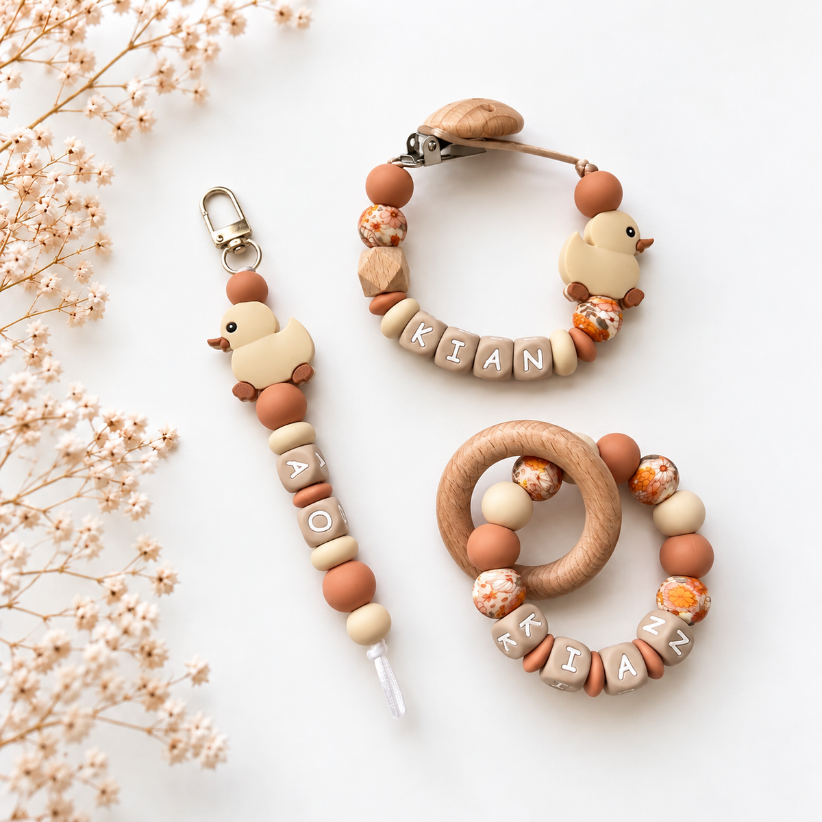 Gepersonaliseerde Honey Duck kraamcadeauset met speenkoord, sleutelhanger en bijtring in bijpassende beige- en bruintinten met eendjesthema.