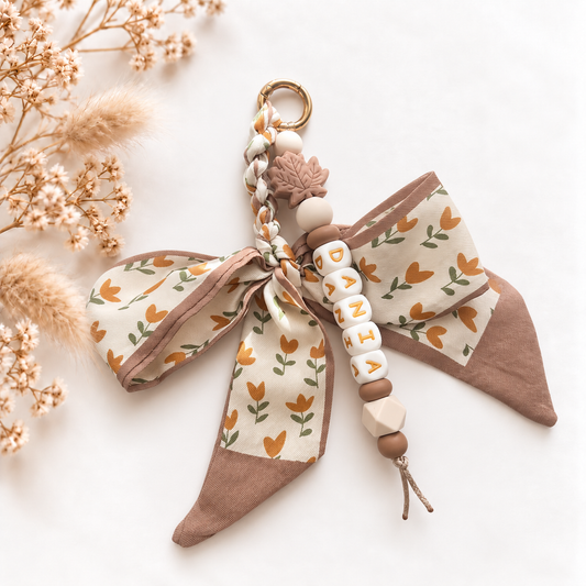 Luxe sleutel- en tassenhanger met naam Autumn Bow met grote beige strik, bloemenpatroon en warme bruintinten