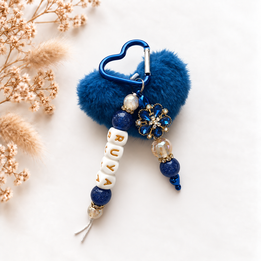 Luxe blauwe tassenhanger met naam Ruya, gouden details en sierlijke bloem