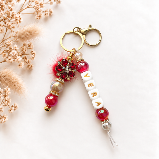 Luxe rode tassenhanger met naam Vera, gouden details en sierlijke bloem