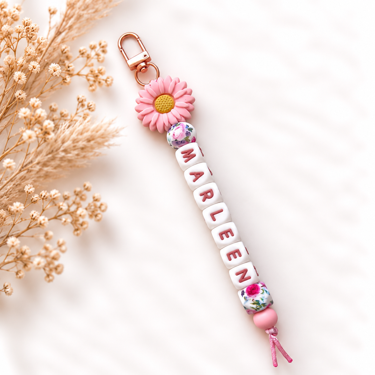 Handgemaakte roze sleutelhanger met naam en kleurrijke bloemendetails