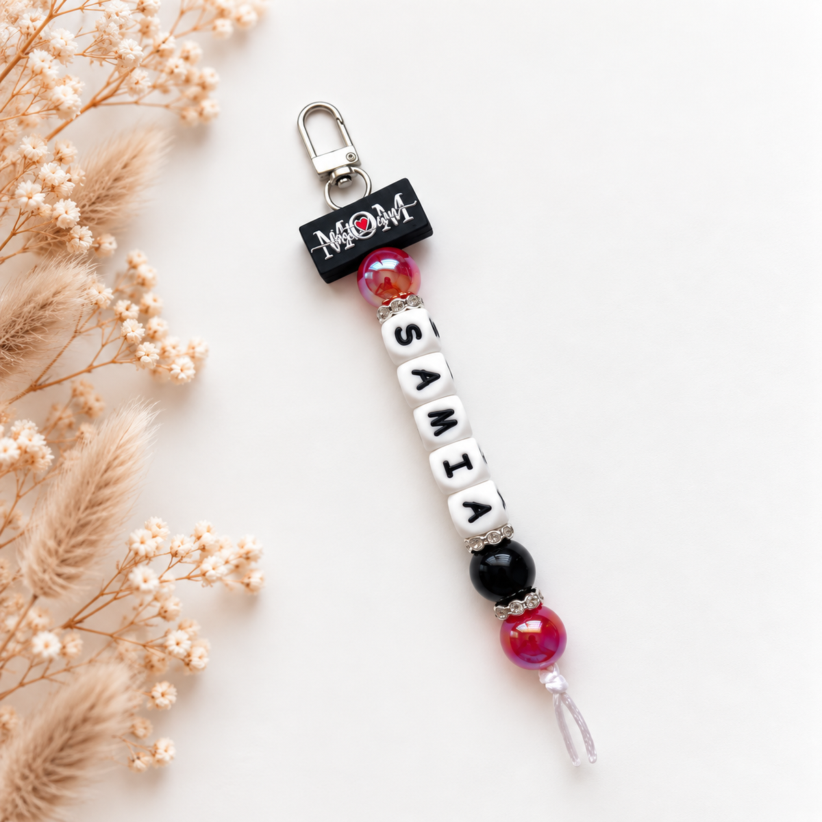 Handgemaakte sleutelhanger met naam Samia in zwart, wit en roze met mama-boodschap
