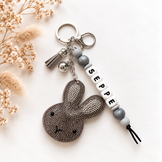 Handgemaakte sleutelhanger en tassenhanger met naam Seppe in grijs, wit en zilver met glinsterend detail