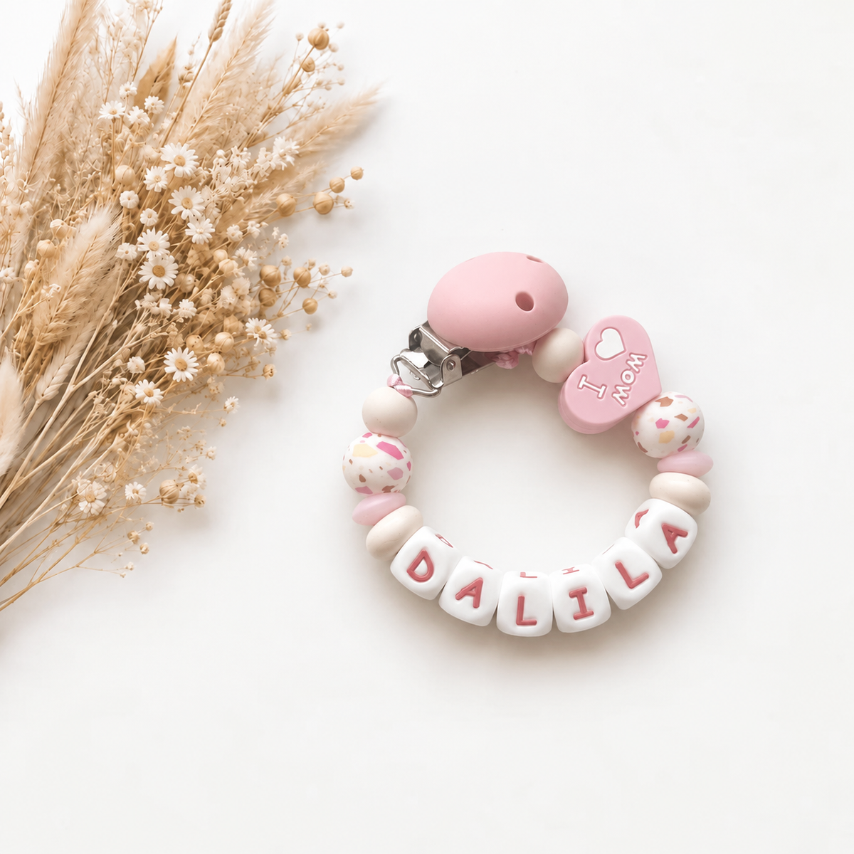 Roze en wit speenkoord met naam en dubbelzijdig hartje met I love Mom en I love Dad