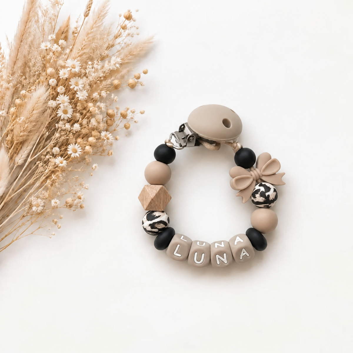 Handgemaakt speenkoord met naam in beige, zwart en wit met strikdetail