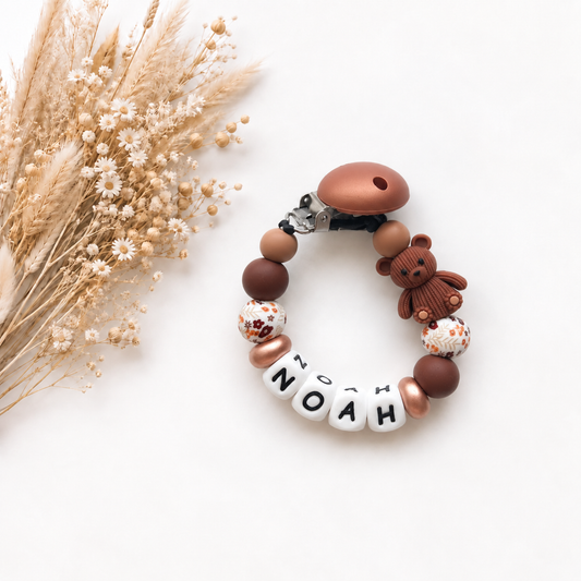 Handgemaakt speenkoord met naam Noah in warme bruintinten met een schattig beertje en bloemendetails